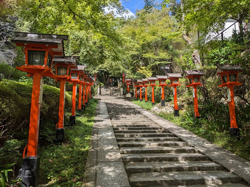 Beautiful stone stairs lined with Japanese lanterns in a lush Kyoto park setting.